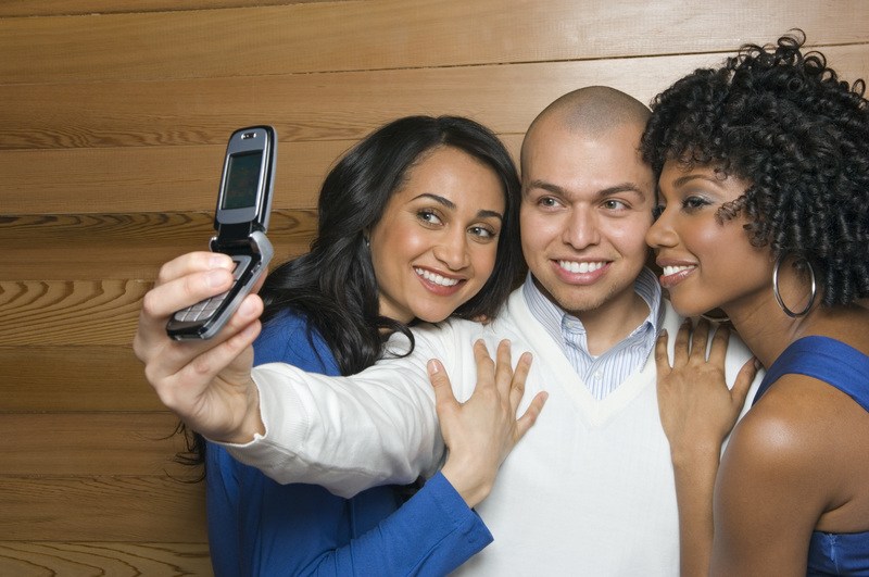 مردی که از خود و دو زن با تلفن همراه عکس می گیرد