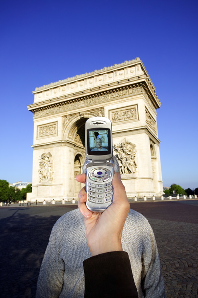 دست شخصی که از تلفن همراه برای عکس گرفتن از مرد در طاق پیروزی، پاریس استفاده می کند