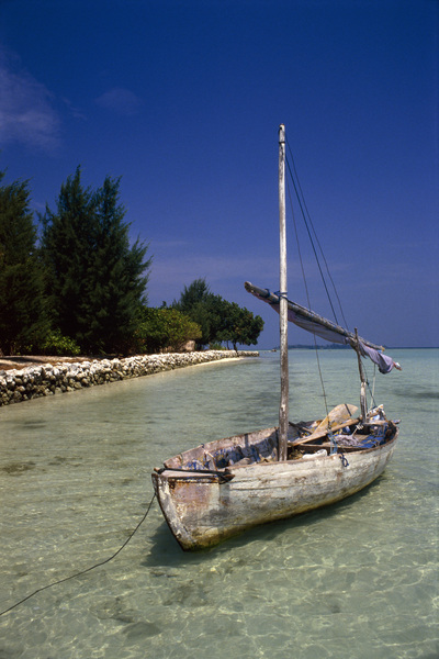 عکس، قایق بادبانی چوبی لنگر انداخته در ساحل، رنگی