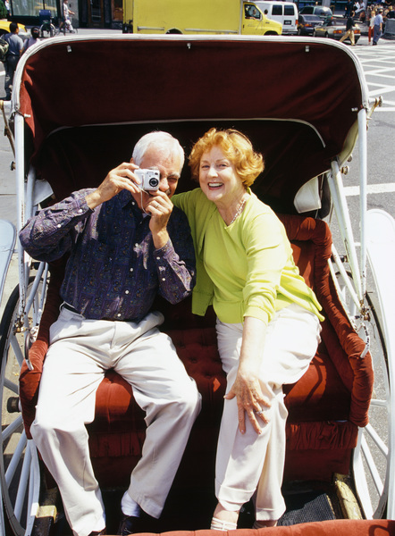 زن و شوهر در کالسکه نشسته اند و مرد در حال عکس گرفتن است