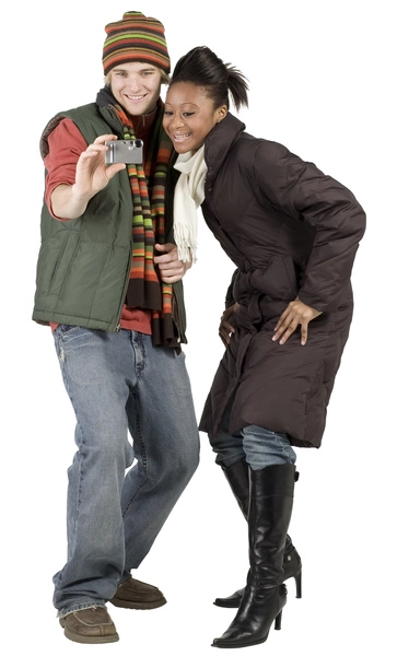 زوج جوانی که لباس های زمستانی پوشیده اند و به تلفن همراه نگاه می کنند